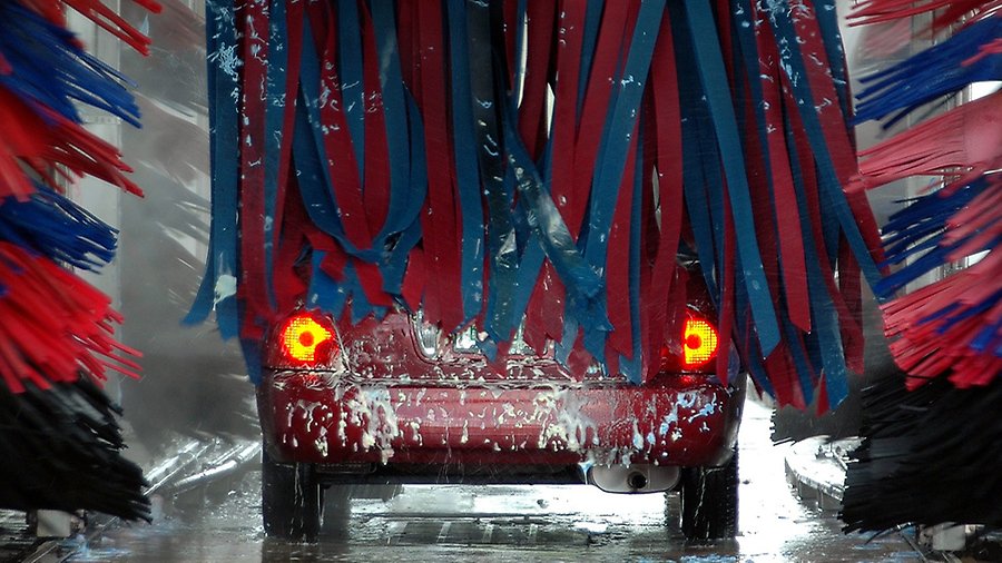 En bil tvättas i en automatisk biltvätt. 